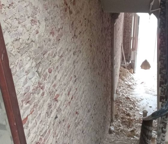 Couloir aux murs décapés jusqu’à la brique
