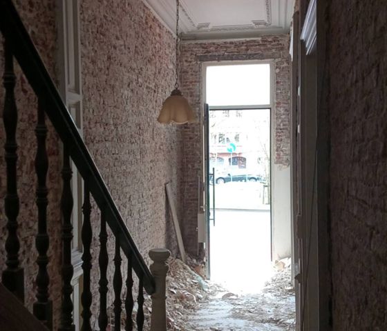 Hall d’entrée après décapage des murs, gravats au sol